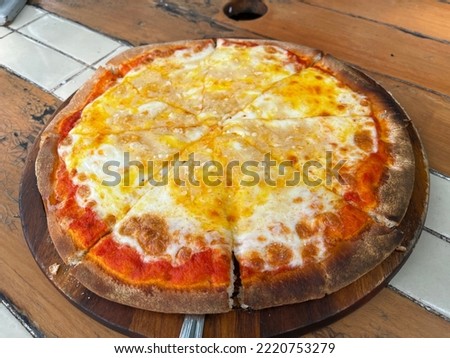 Traditional classic pizza topping with extra mozzarella cheese serving on the wooden pan. Famous comfortable food in Italian restaurant.