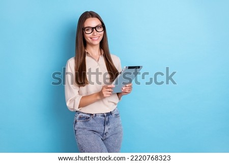 Photo of nice cute gorgeous businesswoman dressed beige shirt jeans hold tablet read book watch video isolated on blue color background
