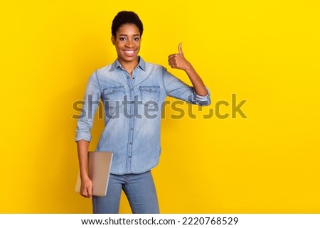 Photo of cheerful person hold netbook hand finger show thumb up feedback rate isolated on yellow color background