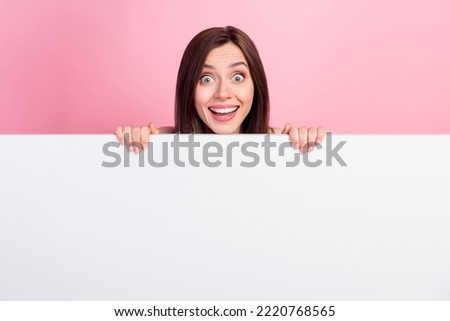 Portrait of funky cute lady hide behind white panel blank space unexpected unbelievable reaction big sale isolated on pink color background Royalty-Free Stock Photo #2220768565