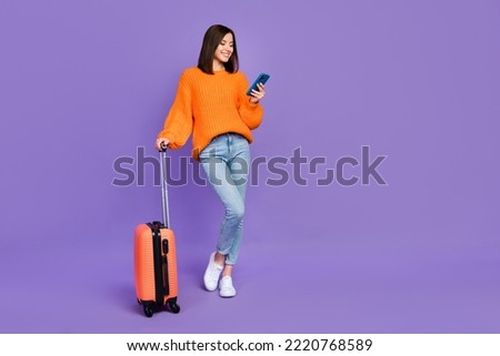 Full size photo of cute young woman hold device taxi service tourist wear trendy orange knitwear outfit isolated on violet color background