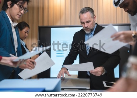 Serious diverse business team leader discuss financial paperwork, Smart businessman and businesswoman partner teamwork talking discussion in group meeting at office table in modern office interior
