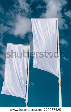 Two cleared advertisement flags waving on the sky