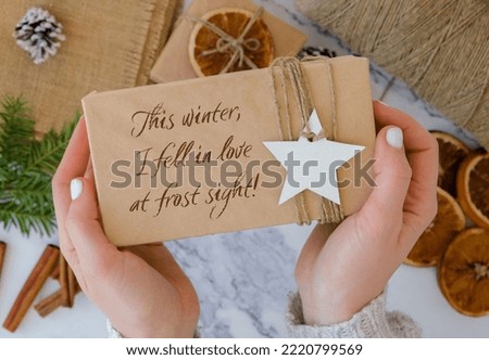 This winter, I fell in love at frost sight Inspiration joke quote phrase Woman making Box with New Year's gifts, wrapped in craft paper and decorated with fir branch. Holidays and Gifts concept