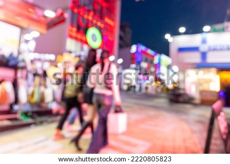 Blurred view of Seoul street with modern buildings, pavements and stylish people walking. Can be used as background. De focused image of capital of south Korea at night