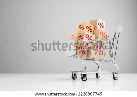 Shopping trolley or cart and boxes with sign discount percent. Black Friday sale products on grey background. Concept of sell or buy with copy space. Shopping cart and red percentage discount Royalty-Free Stock Photo #2220807745