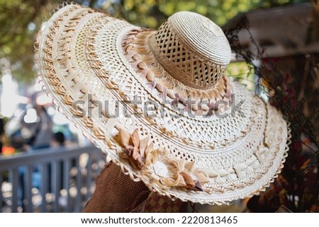 Large beige summer straw hat. Top view of a round straw hat. Woman with a large wide-brimmed hat. Street photo, selective focus, nobody