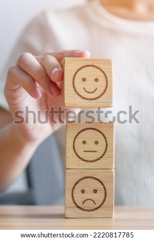 Hand choosing smile face from Emotion block for customer review, good experience, positive feedback, satisfaction, survey, evaluation, assessment, mood, world mental health day concept Royalty-Free Stock Photo #2220817785