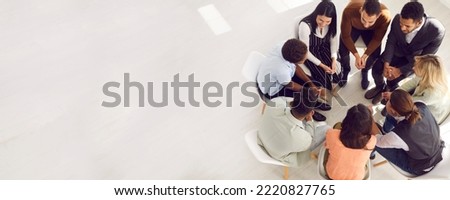 Copy space banner background with coach or psychologist providing professional guidance to group of people. Business team talking while sitting in circle in room with white floor high angle from above