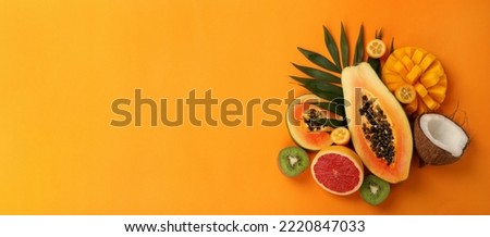 Exotic fruits set on orange background, space for text. Royalty-Free Stock Photo #2220847033