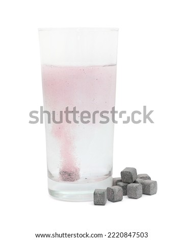 Glass of water with soluble tablets on white background
