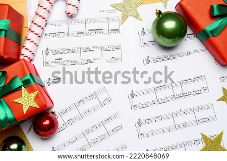 Note sheets with Christmas decor and gifts on wooden background