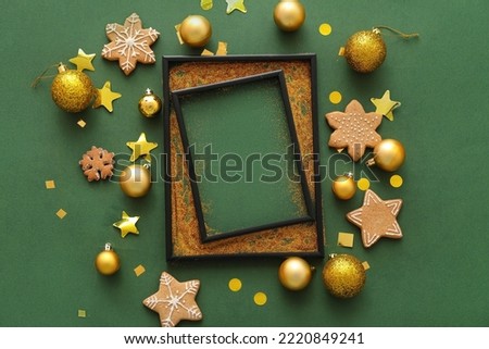 Composition with empty picture frame, Christmas decorations and cookies on green background