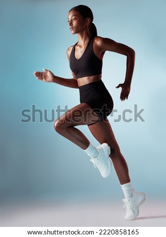 Fitness, health and black woman running in studio with blue background. Sports, exercise and form, motivation for strong runner cardio training for a marathon or race, workout for woman from Jamaica. Royalty-Free Stock Photo #2220858165