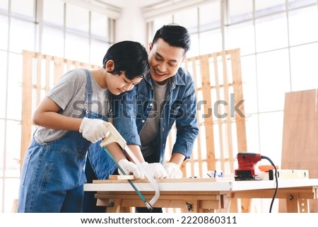 Southeast asian family father and son diy or repair at home concept. Dad teach using tools about carpenter or engineer education skill with child at workshop. Royalty-Free Stock Photo #2220860311