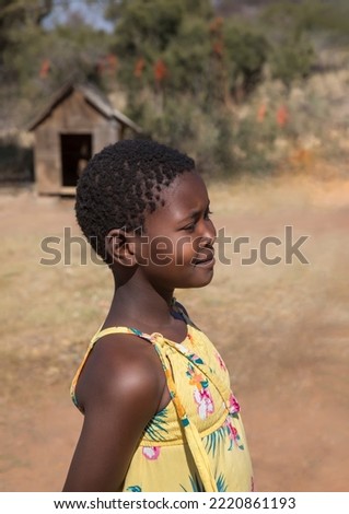 profile portrait of a beautiful village African girl with yellow dress on a simple background