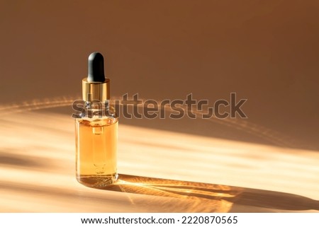 Dropper glass Bottle Mock-Up. dropper pipette with serum or essential oil on beige backgound with caustic shadows for product presentation. Skincare cosmetic. Beauty concept for face body care. Royalty-Free Stock Photo #2220870565