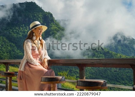 Asian tourist woman picture with foggy mountain, landmark at Khao Kho District, Phetchabun, Thailand.