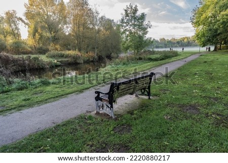 Nantwich Mill Island pathway and bench, foggy autumnal sunrise. Travel and park landscape concept illustration.