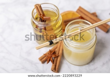 The process of making homemade candles on the table. Close-up. Pouring molten wax. Soy candles handmade with wooden wicks. Vegan product without cruelty to animals.Decor. Royalty-Free Stock Photo #2220893229