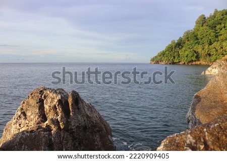 rock cliffs by the sea and a small island on the other side