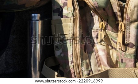 Army camouflage backpack for hiking and hunting. Brown camouflage paint for a bag, close-up photo