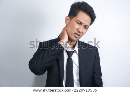 asian young man wearing suit stressed unhappy handsome young man with severe neck pain