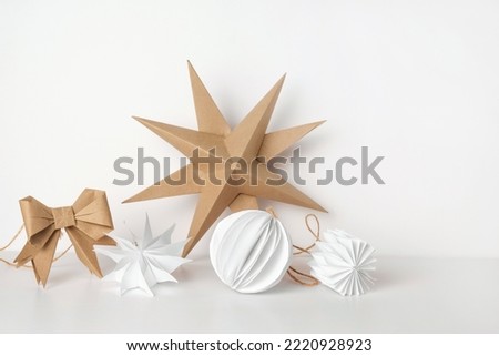 Christmas Paper Star and Ball Decoration. Handmade Christmas Nordic Decor on a Light Background against the Wall. Boho, Scandinavian Style Design. DIY. Minimal Ornament. Structural Origami. Zero Waste