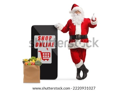 Santa claus leaning on a smartphone with text shop online and gesturing thumbs up isolated on white background