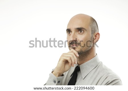 Young adult man watches up concentrated with hand on chin 