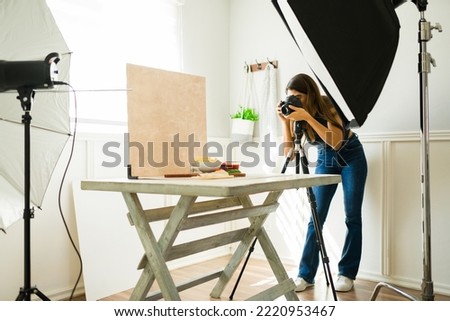 Hispanic female photographer doing a food photo shoot with professional equipment 