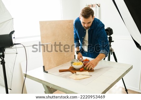 Food photographer doing product styling while preparing to do a professional photo shooting at his studio