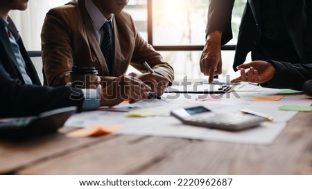 Group of businesspeople meeting and presenting, discussing and analyzing data, pointing to charts and graphs of finance and accounting, business ideas for future growth.