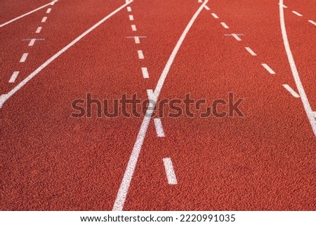 Running racktrack with traction rubber surface at the standard running court stadium, close-up. Sport equipment textured photo.