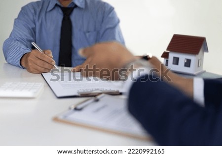 The real estate agent explaining the terms in the legal real estate agreement contract document, waiting for customer to sign. Mortgage, Lease, Home Insurance Concepts