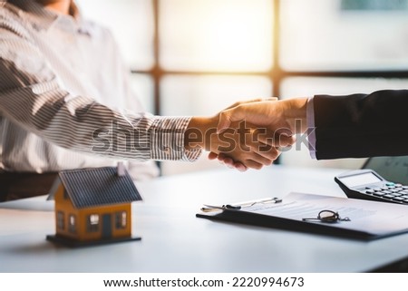 Handshake real estate agents deliver sample homes to customers. mortgage loan agreement Make a contract for hire purchase and sale of a house. and home insurance contracts home mortgage loan concept