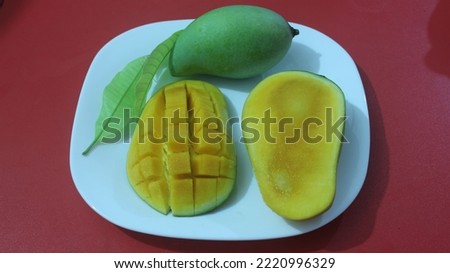 Yellow mango fruit slice cut into cubes on a white plate. mango isolated red background. no edit Picture Soft photography