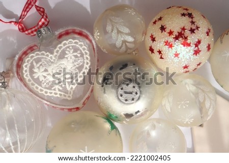 White and transparent Christmas tree ornaments, illuminated by sunlight. Flat lay.