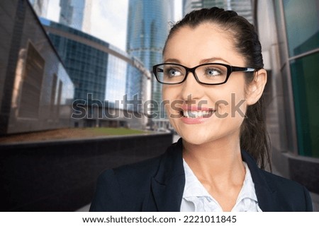 Smiling business woman holding digital table on city background