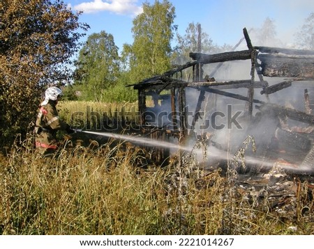 Russian firefighters at work. Extinguishing a burning wooden house. Leningrad region, Russia.