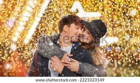 love winter couple in christmas lighted city at snowfall
