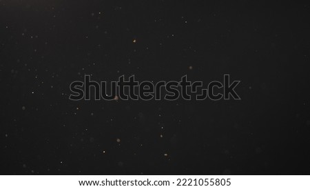 real dust particles in air with back light over black background