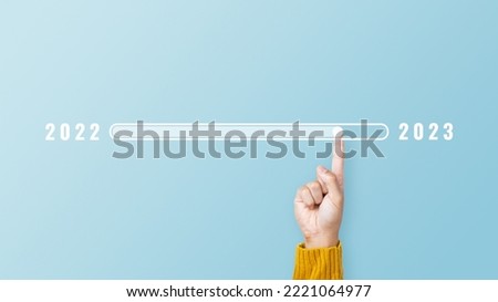 Man hand touching loading bar for countdown to 2023. Loading year 2022 to 2023. Start concept Royalty-Free Stock Photo #2221064977