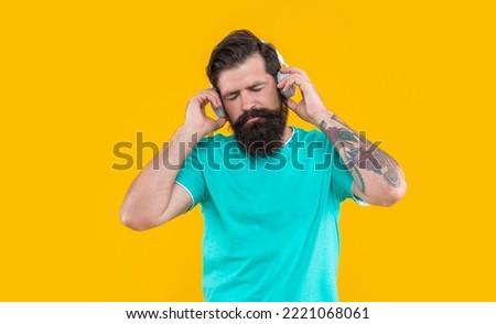 sleepy dj guy in music headphones isolated on yellow background. dj guy wearing music headphones