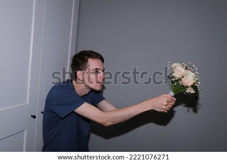 cute guy holding a bouquet of flowers in his hands