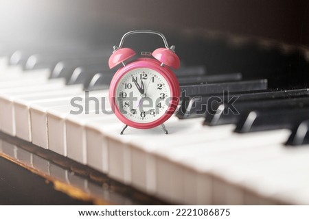 Retro alarm clock stand on vintage piano