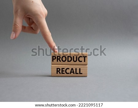 Product recall symbol. Concept words Product recall on wooden blocks. Beautiful grey background. Businessman hand. Business and Product recall concept. Copy space.