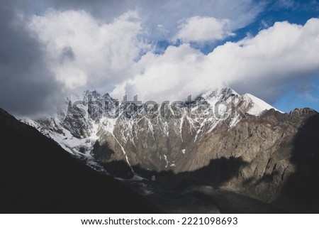 Snowy mountain peaks. Clouds and rocks.