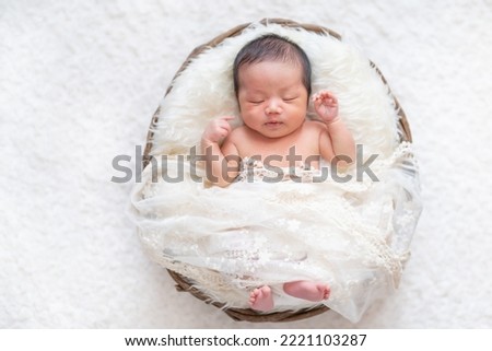 A newborn baby sleeping peacefully in a basket (newborn photo) Royalty-Free Stock Photo #2221103287