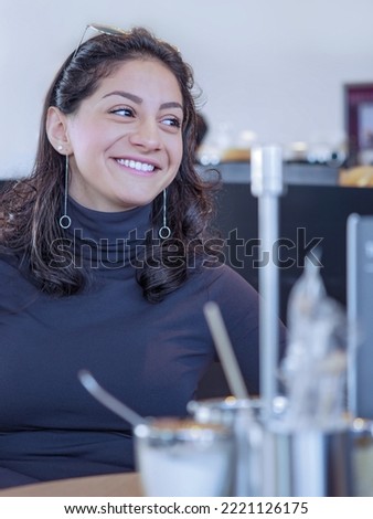  Portrait of beautiful smiling young woman who relaxing in cafe.